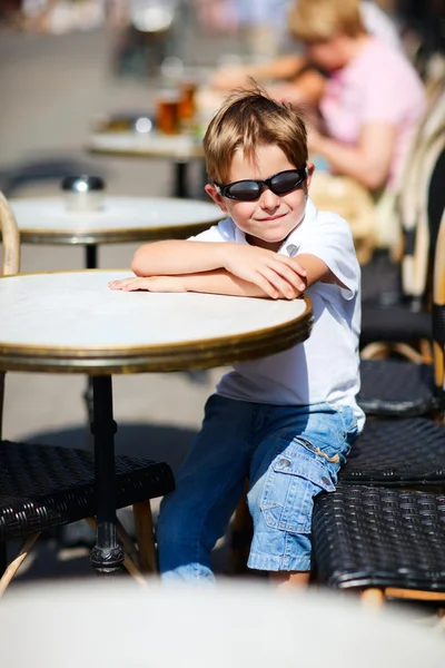 Menino sentado no café ao ar livre — Fotografia de Stock