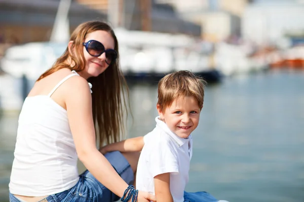 Mother and son sitting on jetty in city center — Stock Photo, Image