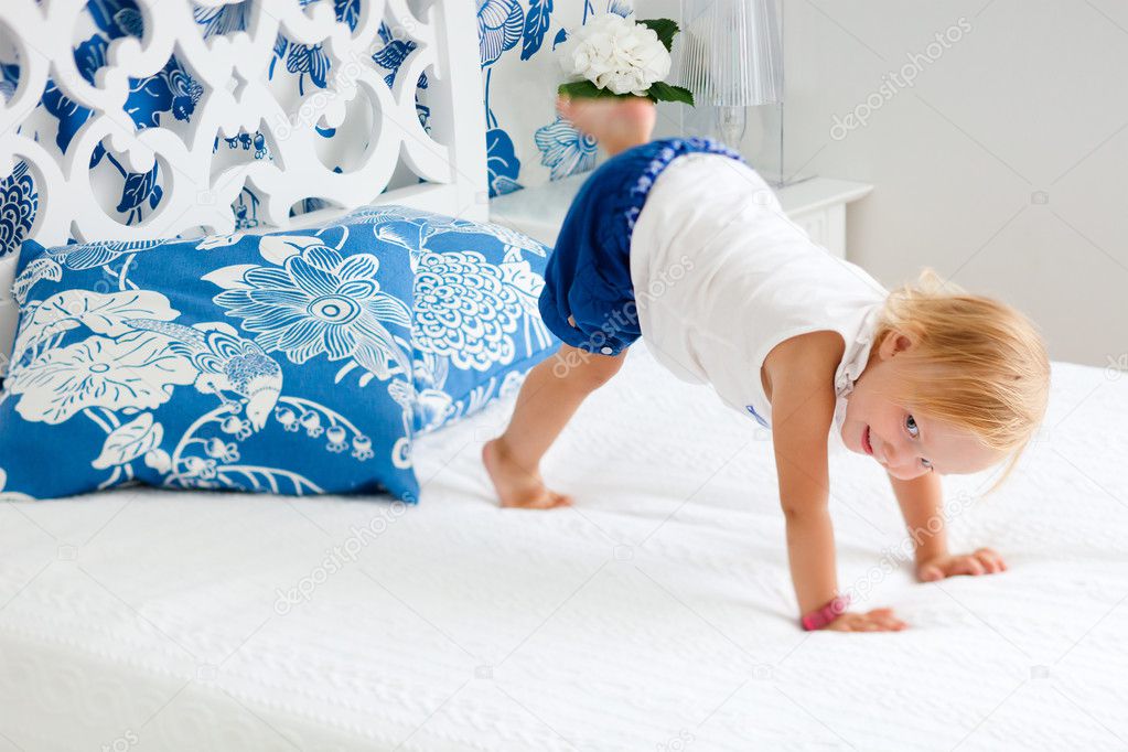 Adorable playful toddler girl in bedroom