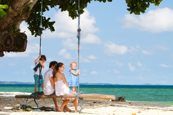 Familia balanceándose en la playa tropical —  Fotos de Stock