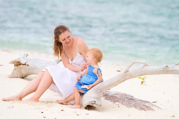 Мать и дочь на тропическом белом песчаном пляже — стоковое фото