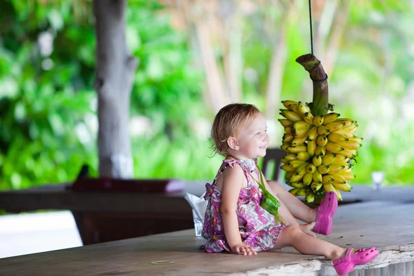 Κορίτσι μικρό παιδί σε εξωτερικούς χώρους με δέσμη μπανανών — Φωτογραφία Αρχείου