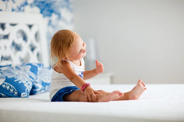 Πορτραίτο κοριτσιού παιχνιδιάρικο μικρό παιδί που κάθεται στο κρεβάτι — Φωτογραφία Αρχείου