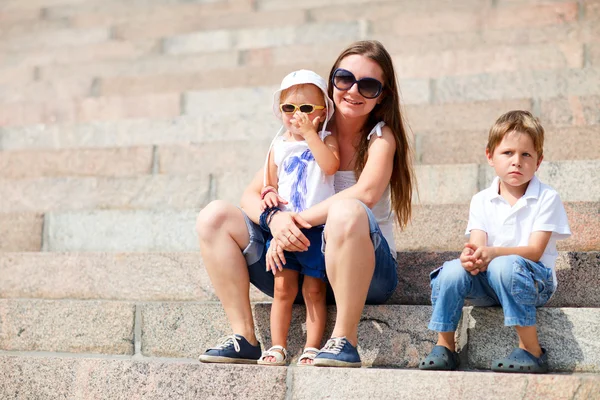 Семья сидит на ступеньках на улице — стоковое фото