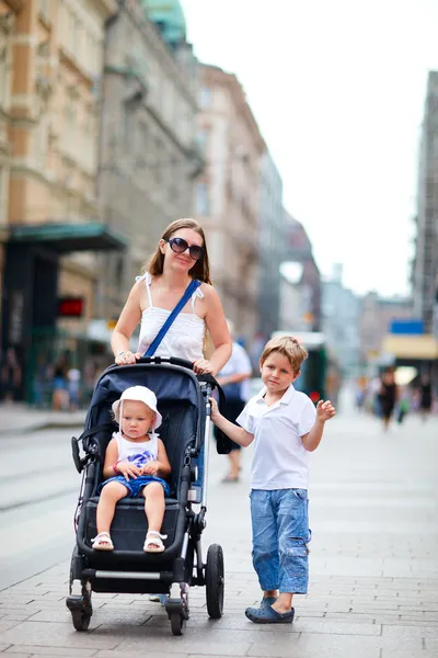 Matka a dvě děti, které chodí v centru města — Stock fotografie