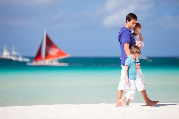 Vater und zwei Kinder laufen am Strand entlang — Stockfoto