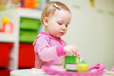 Toddler girl playing with toys clipart