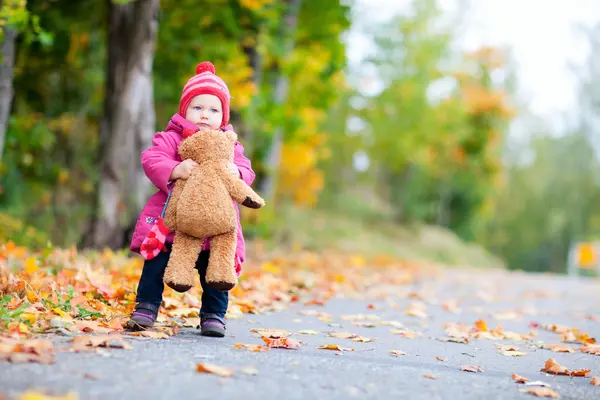 Peuter meisje met teddybeer buitenshuis op herfstdag — Stockfoto