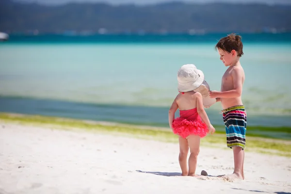 Dos adorables niños de pie junto a la orilla del océano — Foto de Stock
