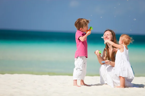 Mutter und Kinder amüsieren sich am Strand — Stockfoto