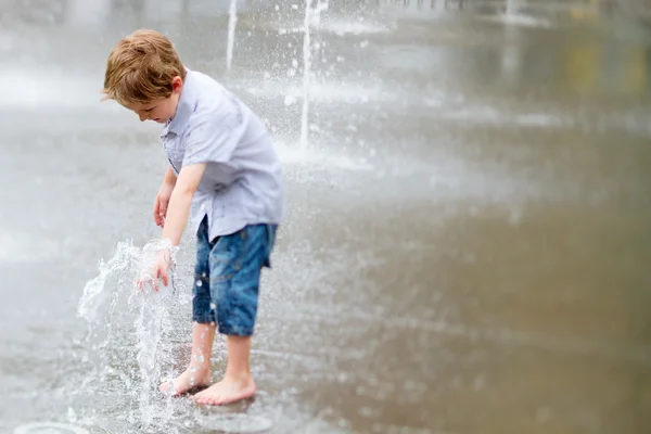 Ładny mały chłopiec bawi się wody na zewnątrz — Zdjęcie stockowe