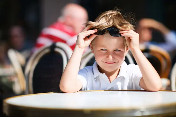 Menino sentado no restaurante ao ar livre — Fotografia de Stock