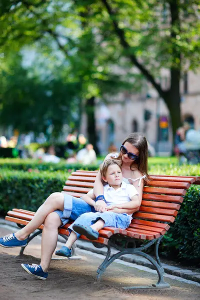 Mother and son sitting outdoors — Stock Photo, Image