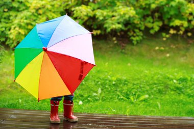 Little girl hiding behind umbrella clipart