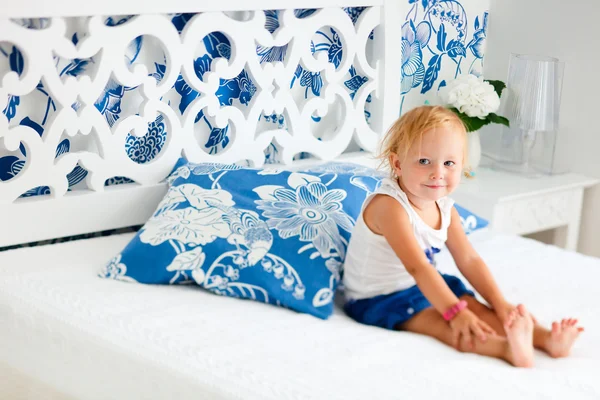 Kisgyermek lány ül az ágyon — Stock Fotó