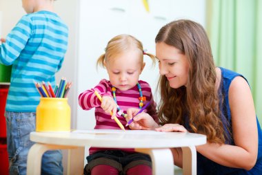 Mother drawing together with her daughter clipart