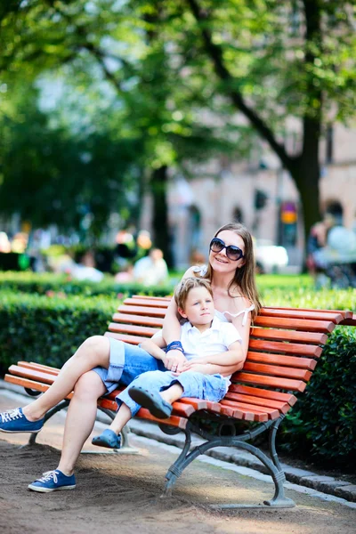 Mother and son on bench in park — Stock Photo, Image