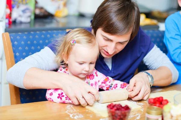 Девочка Тоддлер и ее отец пекут пироги — стоковое фото
