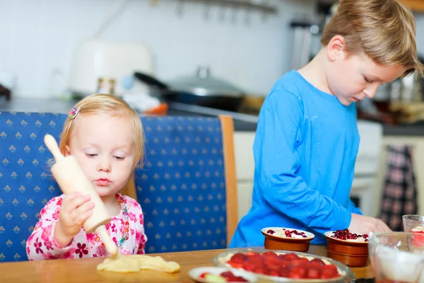 Двое детей, помогающих печь пирог — стоковое фото