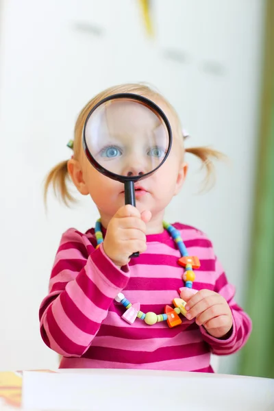 Barn flicka som leker med förstoringsglas — Stockfoto