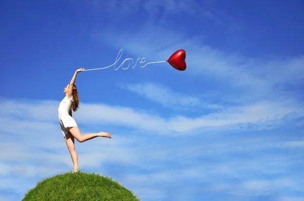 Girl with a red balloon in the form of heart — Stock Photo, Image