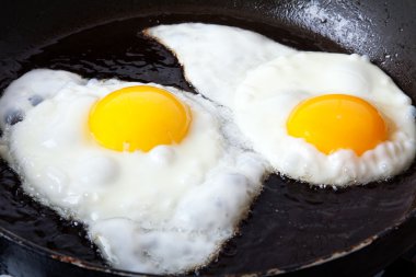 Eggs frying in oil clipart