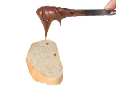 Spreading chocolate cream on bread slice clipart