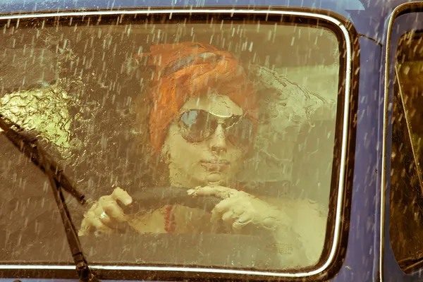 Menina vintage carro de condução sob chuva — Fotografia de Stock