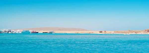 Yacht vicino spiaggia e isola rocciosa — Foto Stock