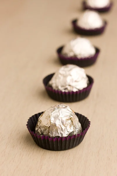 stock image Choco candies in golden foil on table