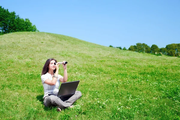 Woman with spyglass and notebook on grass — Stock Photo, Image