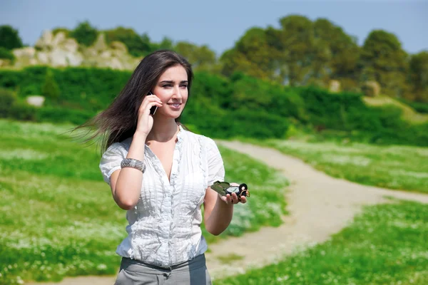 Pretty woman speaking on phone with compass — Stock Photo, Image