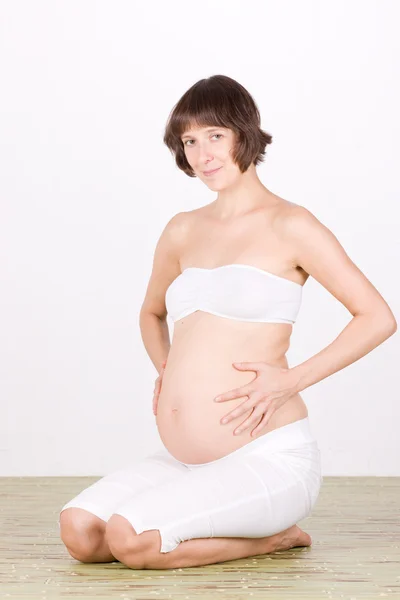 Těhotná žena sedí na podlaze — Stock fotografie
