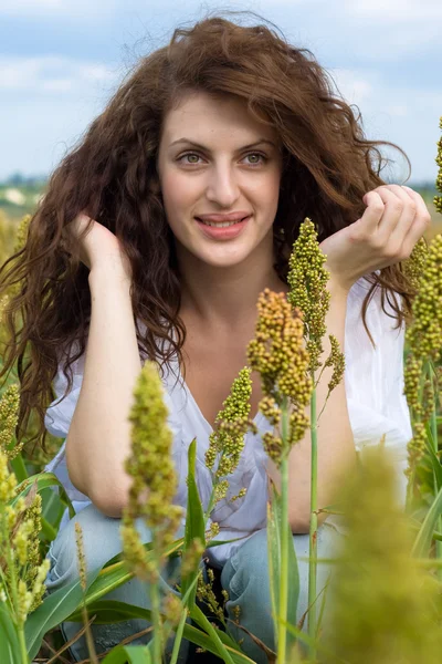 Šťastná žena v poli s vlnité vlasy — Stock fotografie