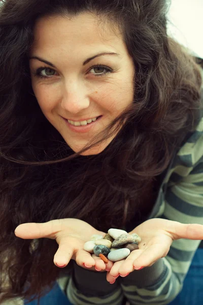 Vacker kvinna anläggning små stenar — Stockfoto