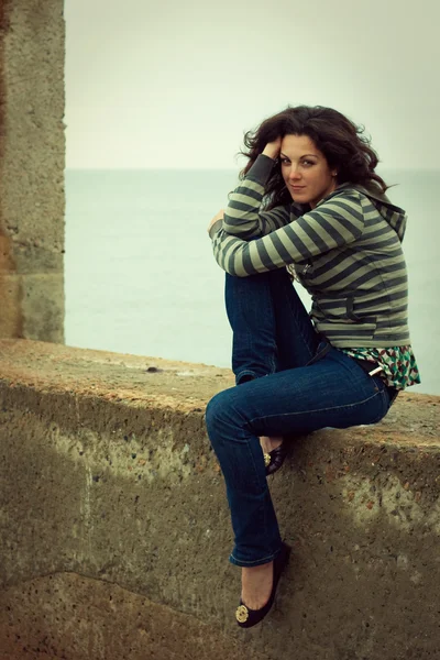 Žena sedí na vlnolam — Stock fotografie