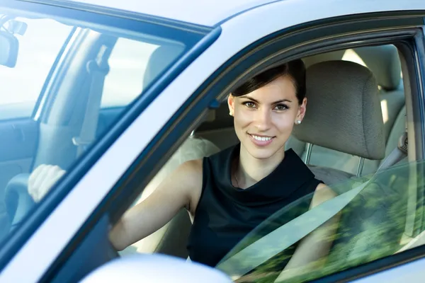 Frau am Steuer ihres Autos lizenzfreie Stockfotos