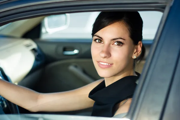 Счастливая женщина за рулем своего автомобиля — стоковое фото