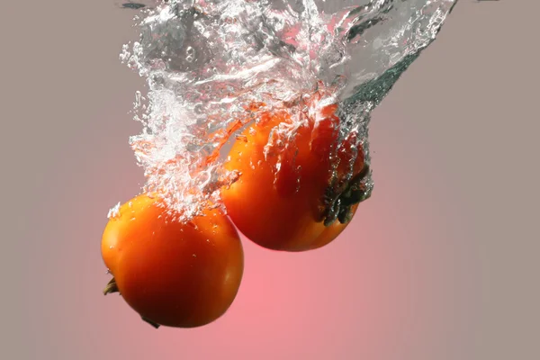 Isolerade röda tomater i vatten — Stockfoto