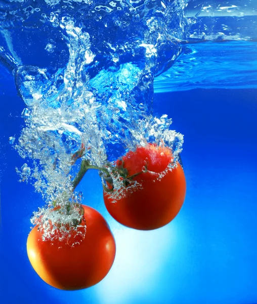 Tomates vermelhos isolados em água — Fotografia de Stock