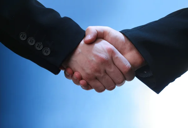 Business handshake on blue — Stock Photo, Image