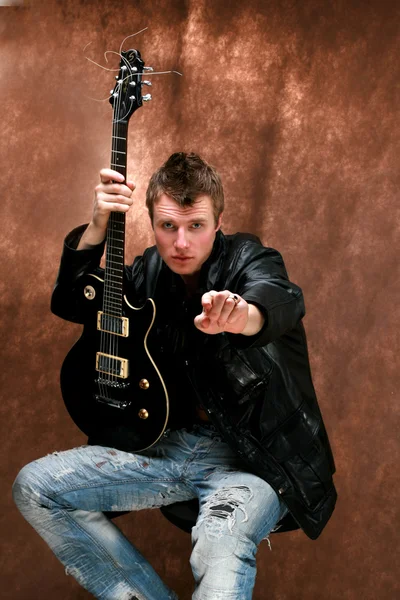 The young man with a guitar — Stock Photo, Image