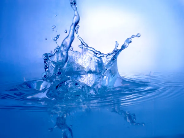 Étincelles d'eau bleue sur un fond bleu — Photo