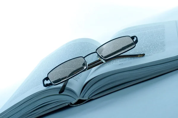 Βιβλίο και γυαλιά που απομονώνονται σε λευκό Royalty Free Φωτογραφίες Αρχείου
