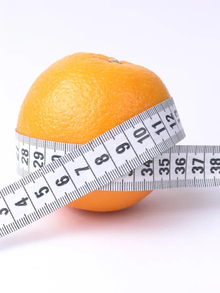 Orange embraced by a measuring tape Royalty Free Stock Photos