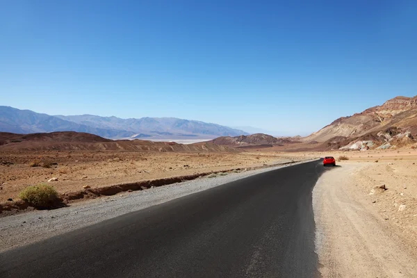 Бесконечное шоссе и красный автомобиль — стоковое фото