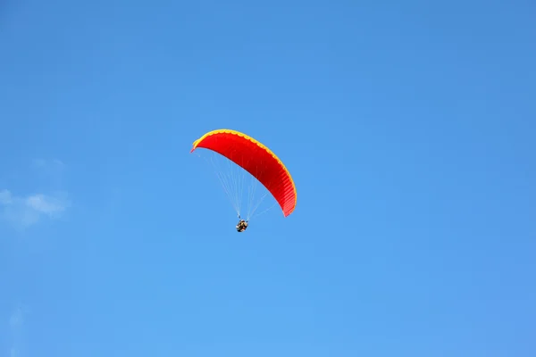 Opererade röda fallskärm flyger i hög — Stockfoto