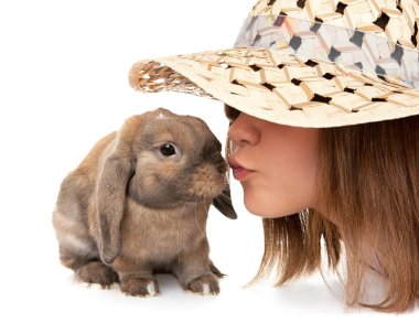 Girl in a straw hat kisses dwarf rabbit. clipart