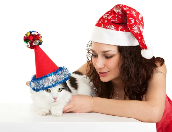 Schöne Mädchen mit einer Katze in Neujahrsmützen. — Stockfoto