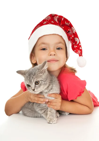 Malá holčička v novém roce čepici s kotětem. — Stock fotografie